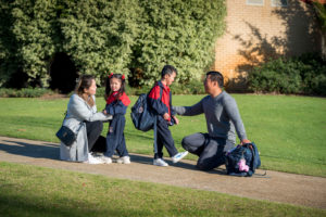 Kindergarten students with their family outside the school campus