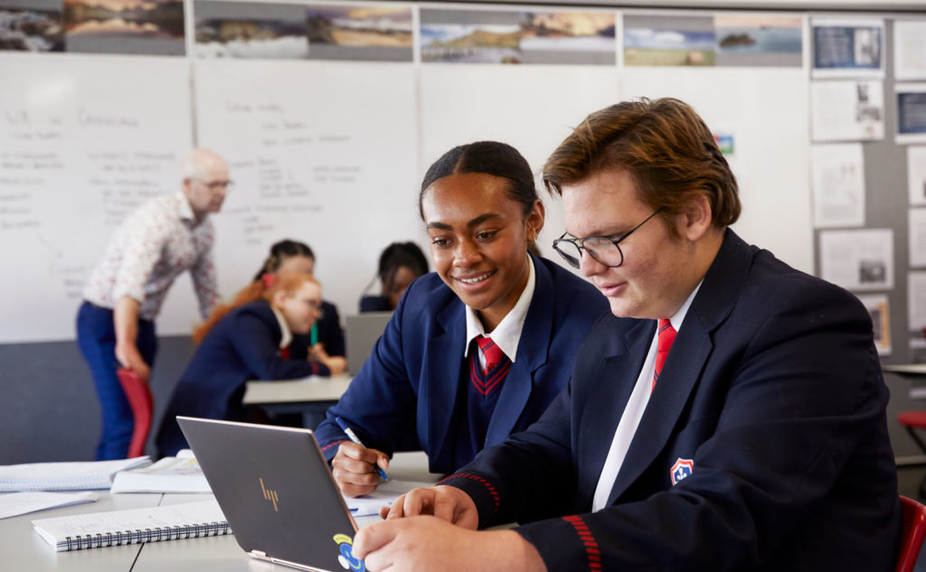 A Secondary school boy and girl doing work on a computer in information technology class