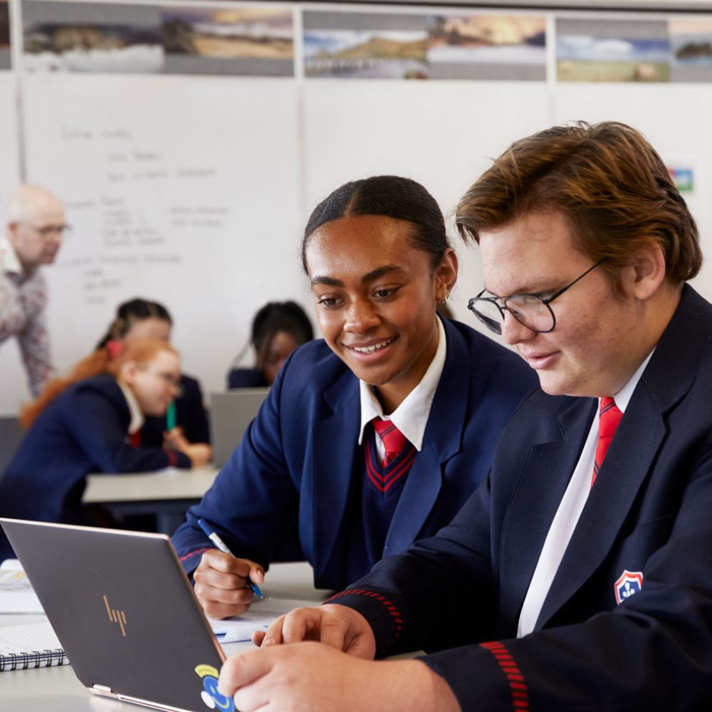 A Secondary school boy and girl doing work on a computer in information technology class